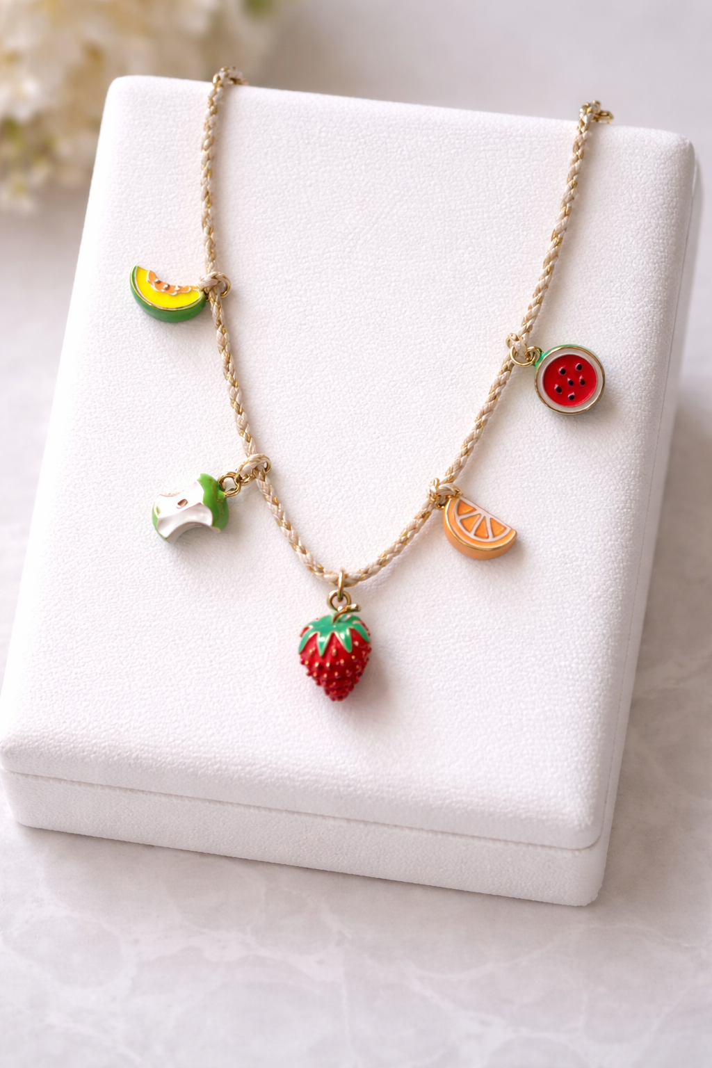 Enamelled fruits in string chain
